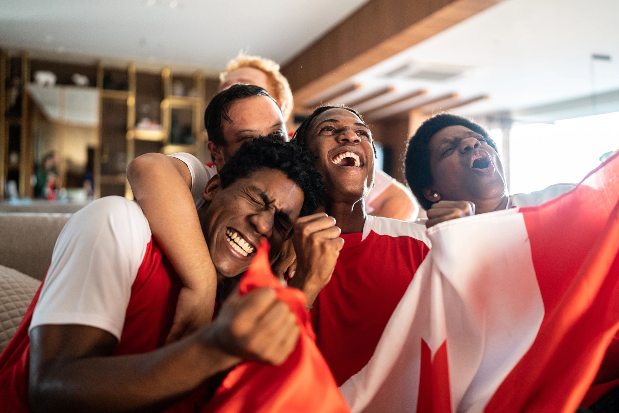 Friends celebrating while watching sports at home
