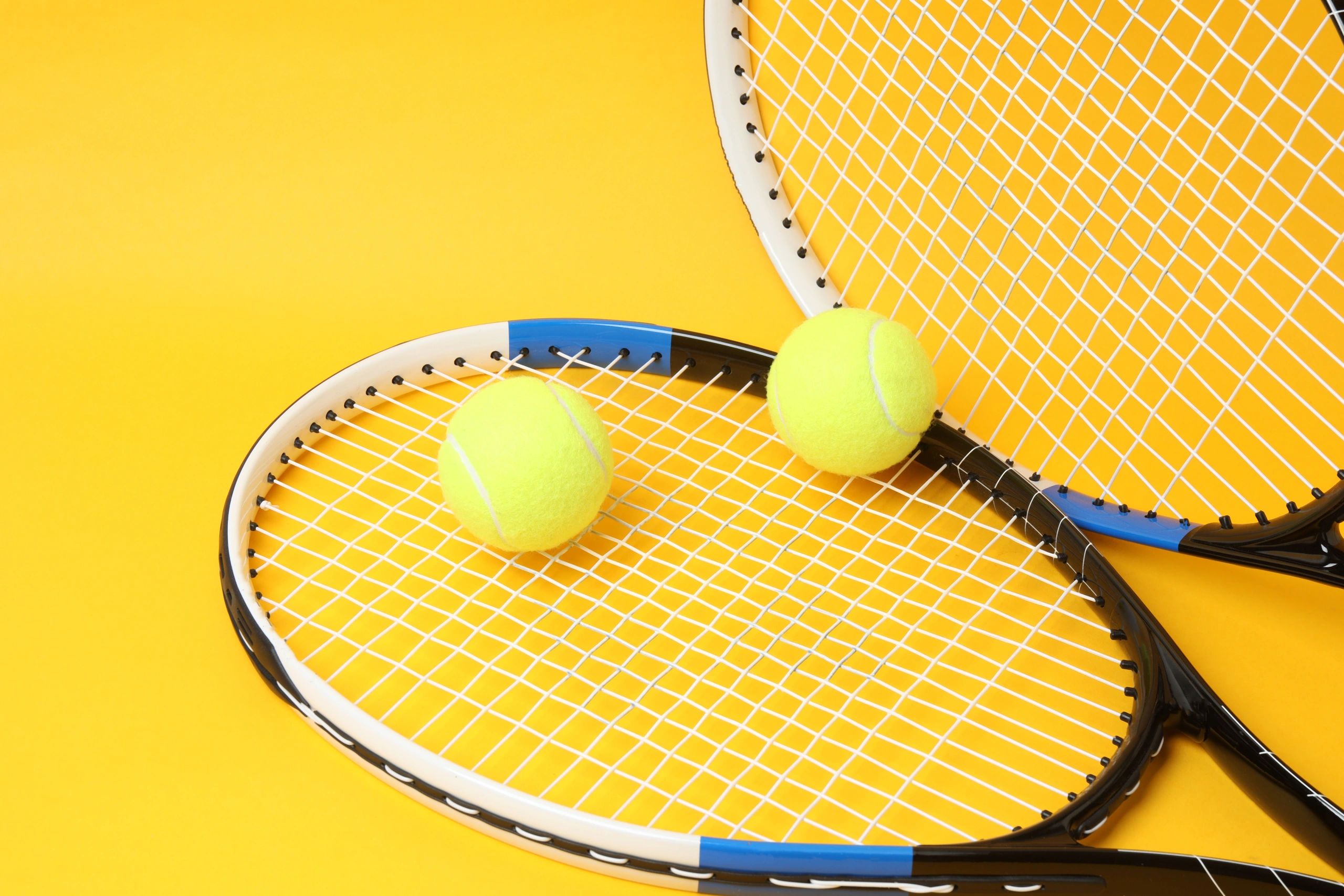 Tennis racket and balls on a bright background