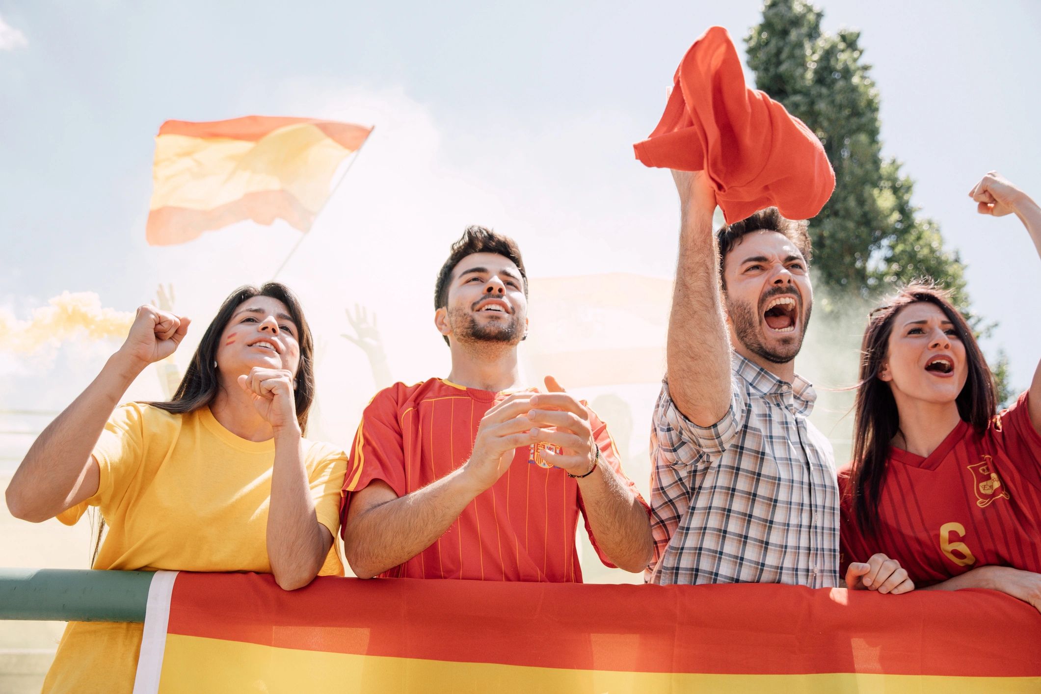 Fans cheering in the stands behind a large flag